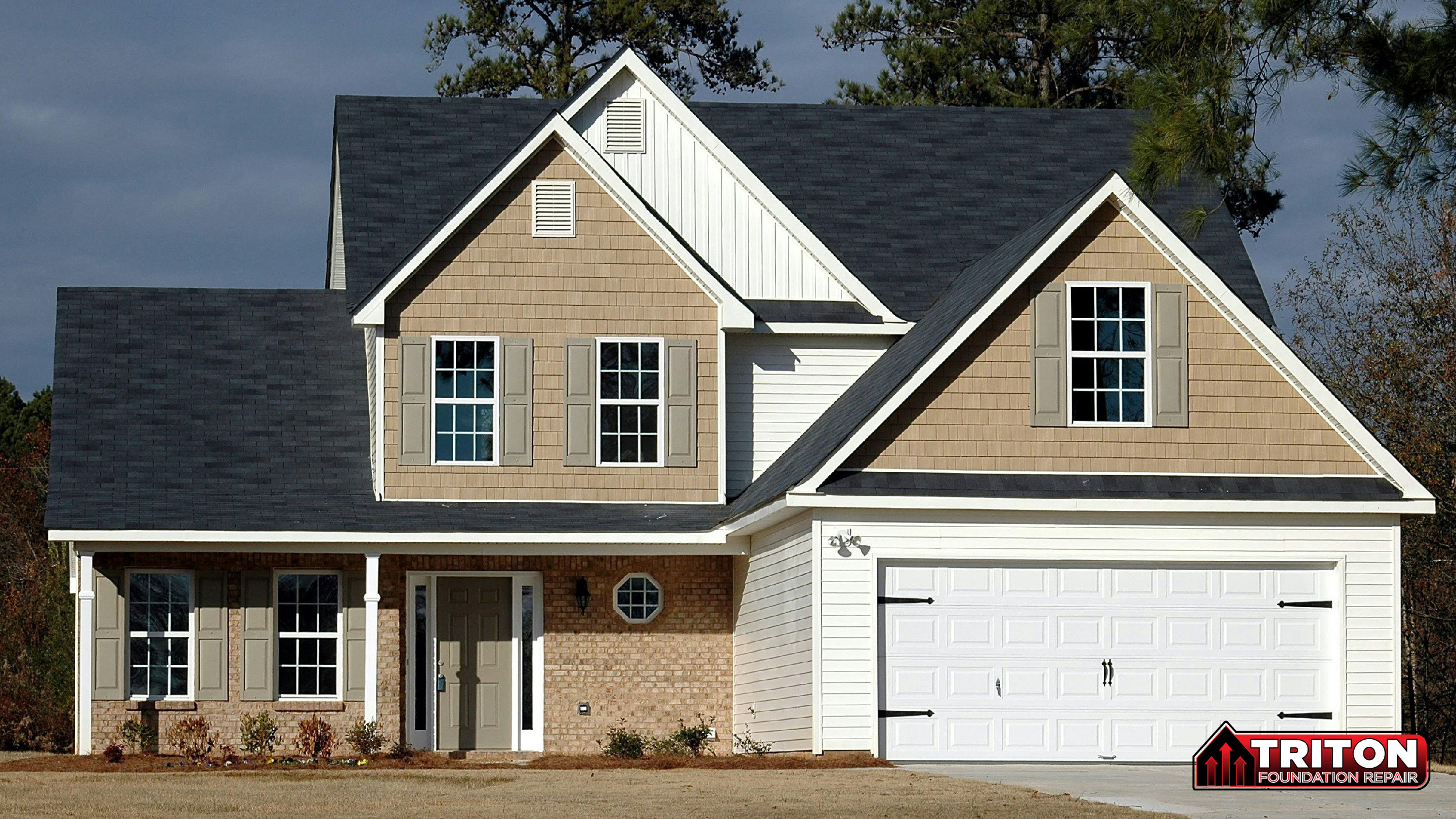 A tan and white two-story suburban house with a dark gray roof